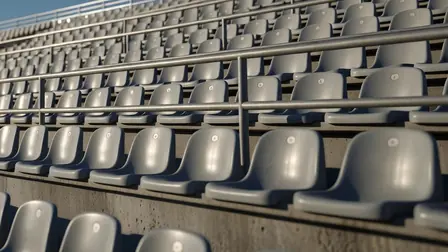 Rows of empty grey seats in a stand at dusk